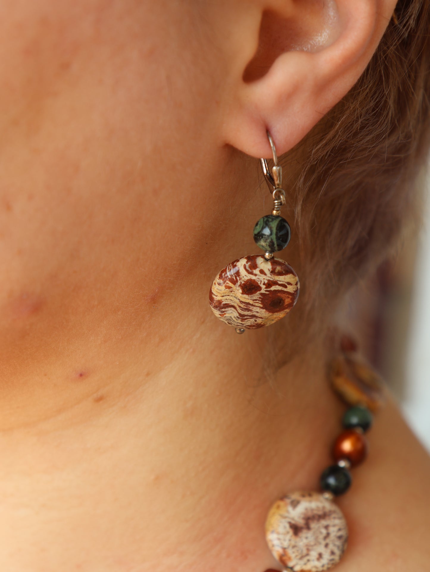 Close-up of a person wearing a beaded earring with a blurred background